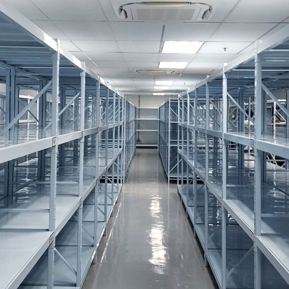 Rows of white steel shelving in a clean storage room
