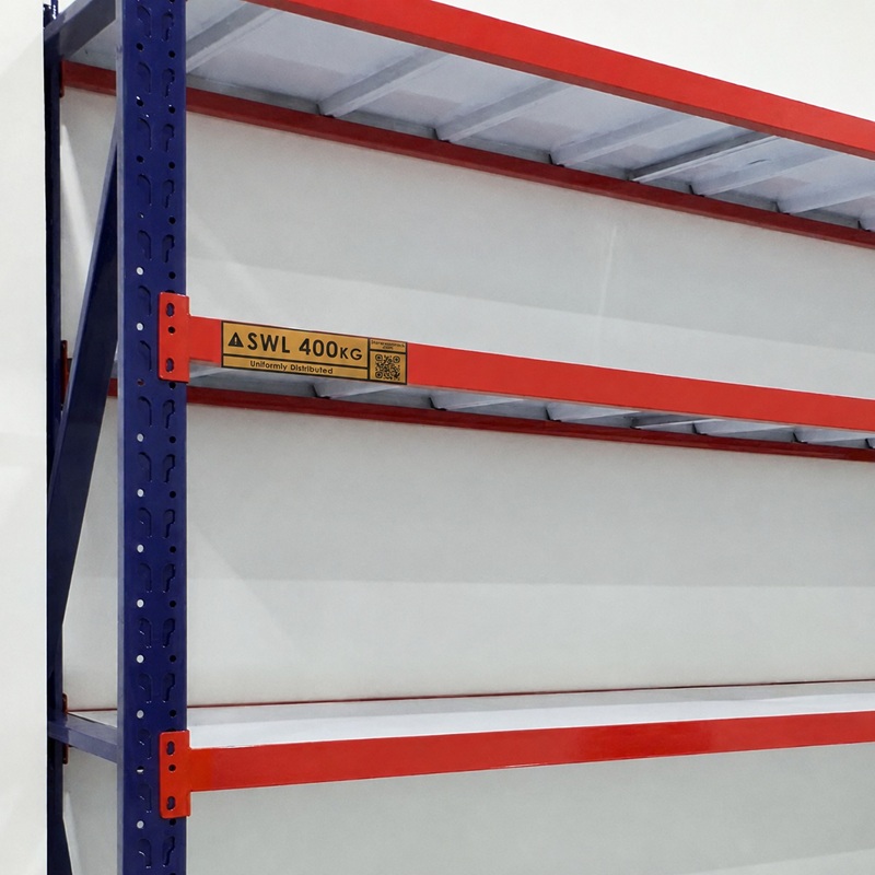 Close-up of a warehouse rack upright with a safe working load label on the orange beam